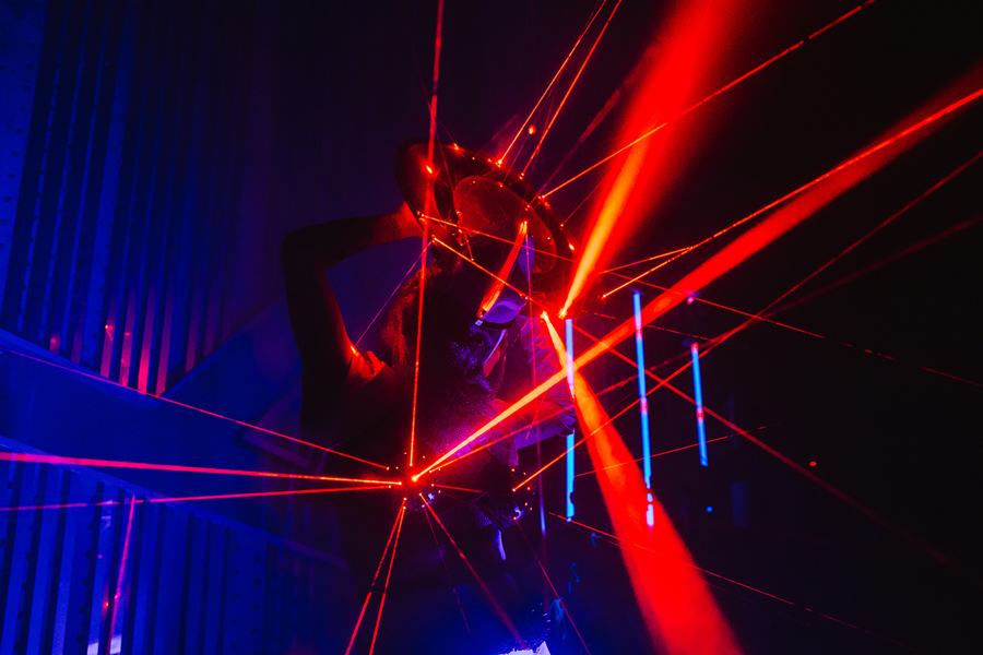 Performer surrounded by red and blue laser beams